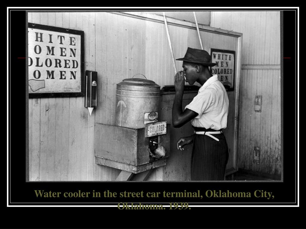 Negro drinking at Colored water cooler in streetcar terminal